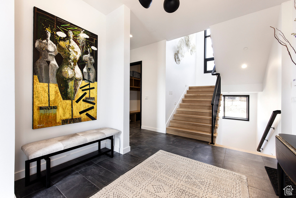 Entrance foyer with baseboards, stairway, and recessed lighting