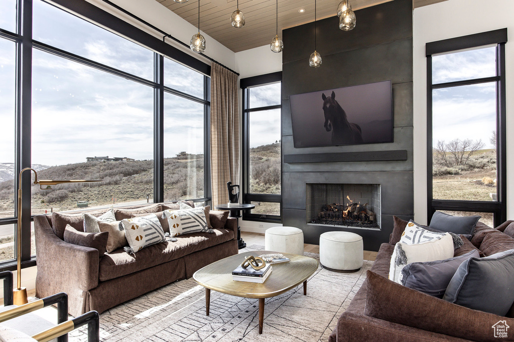 Living room featuring a large fireplace and wood ceiling