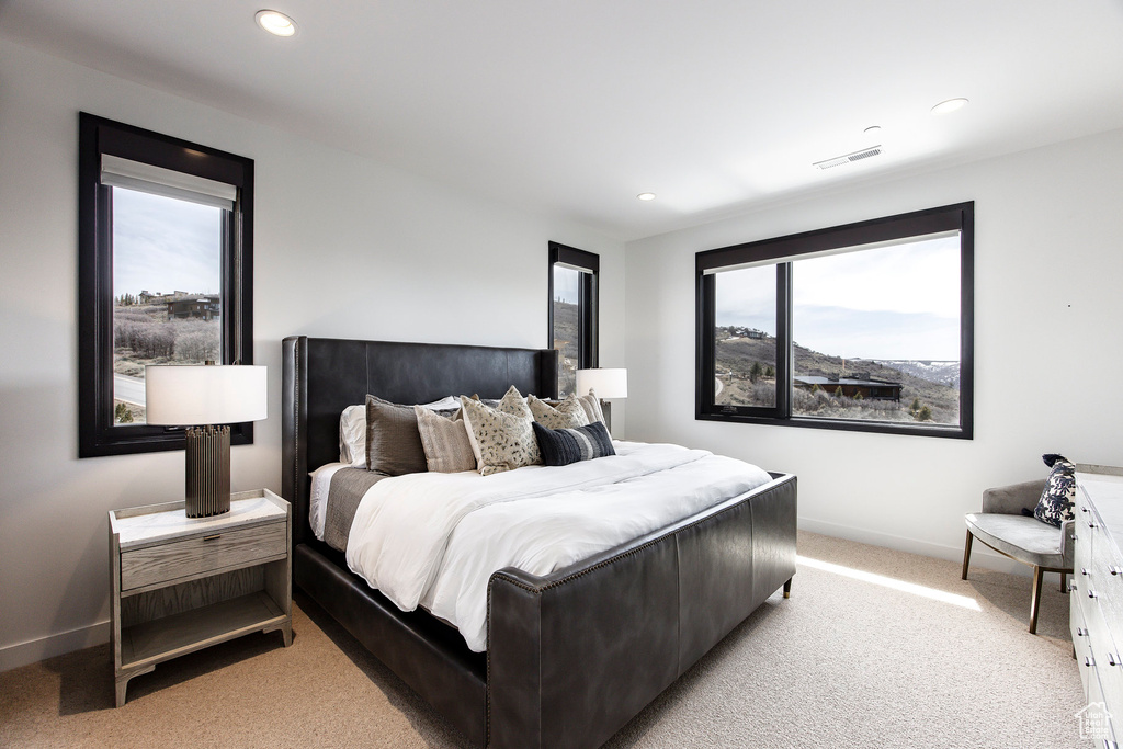 Bedroom with light colored carpet, baseboards, and recessed lighting
