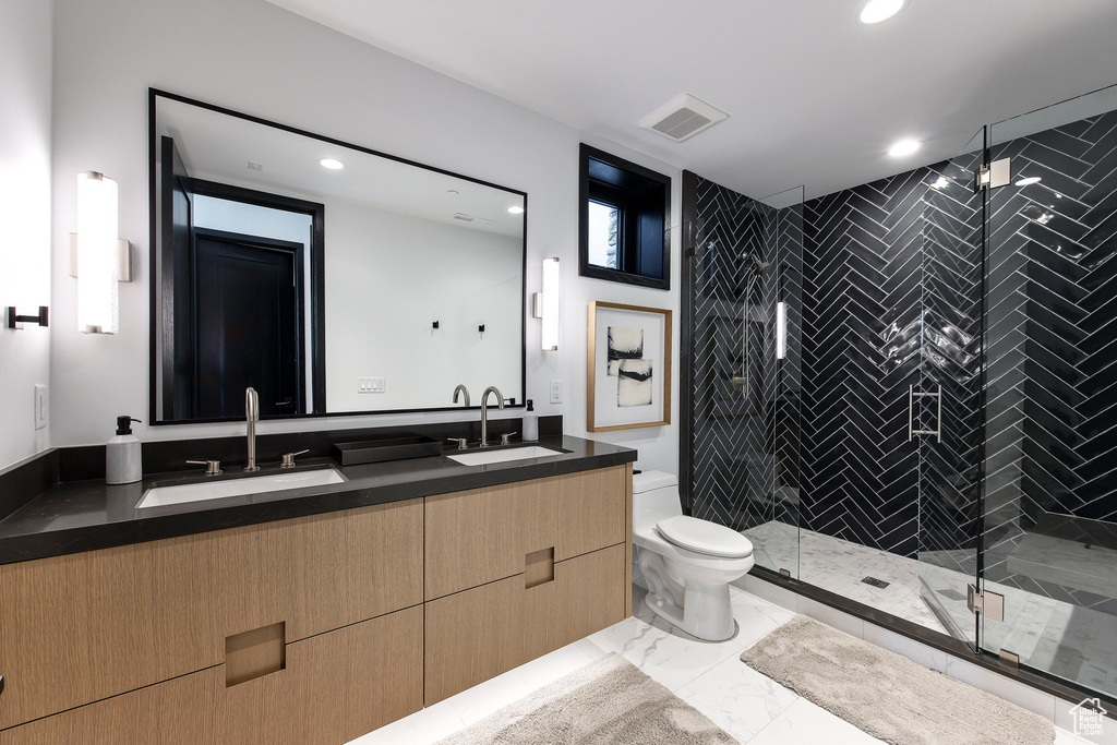 Full bath with toilet, a stall shower, recessed lighting, double vanity, and marble finish flooring