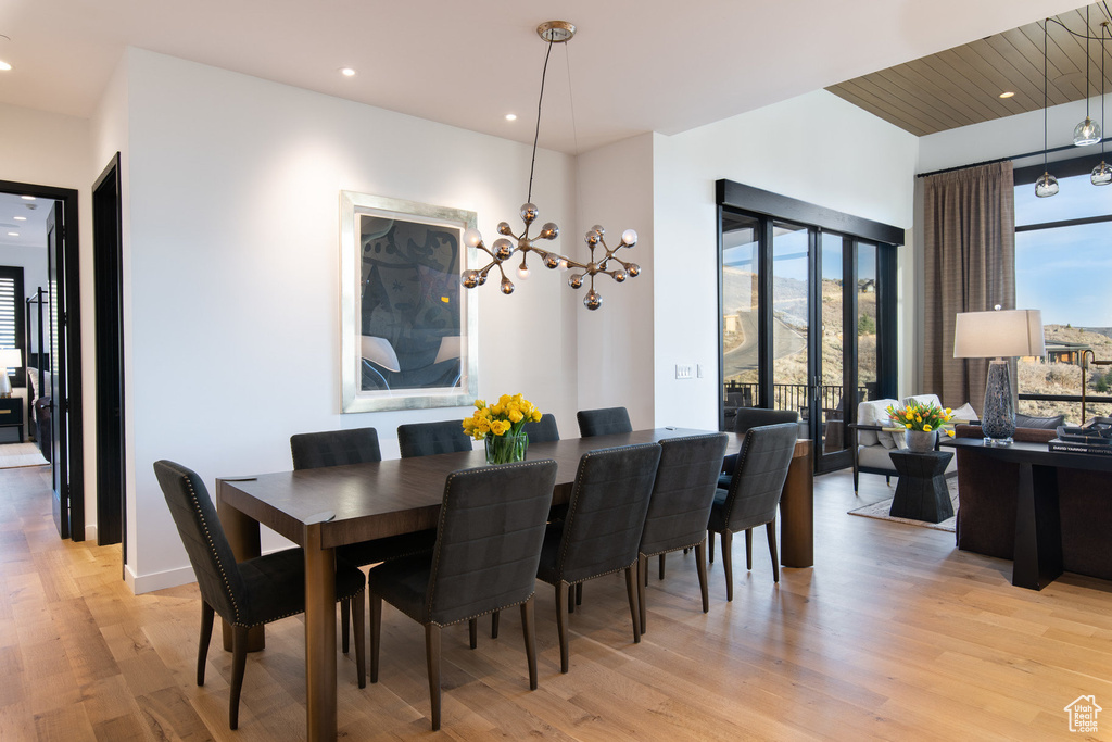 Dining space with light wood finished floors, a chandelier, and recessed lighting