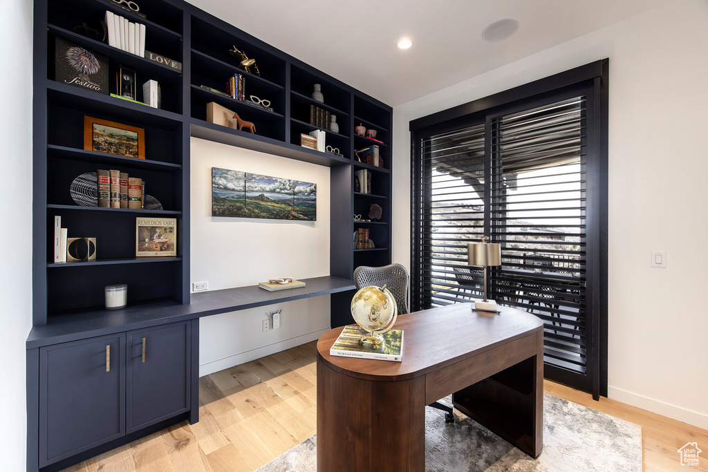 Office with light wood-style floors, baseboards, and built in features