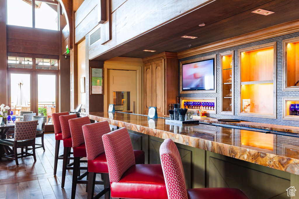Bar featuring plenty of natural light, hardwood / wood-style floors, and decorative backsplash