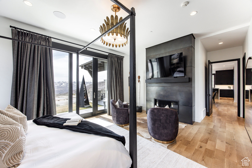 Bedroom featuring access to exterior, light wood-style floors, and recessed lighting