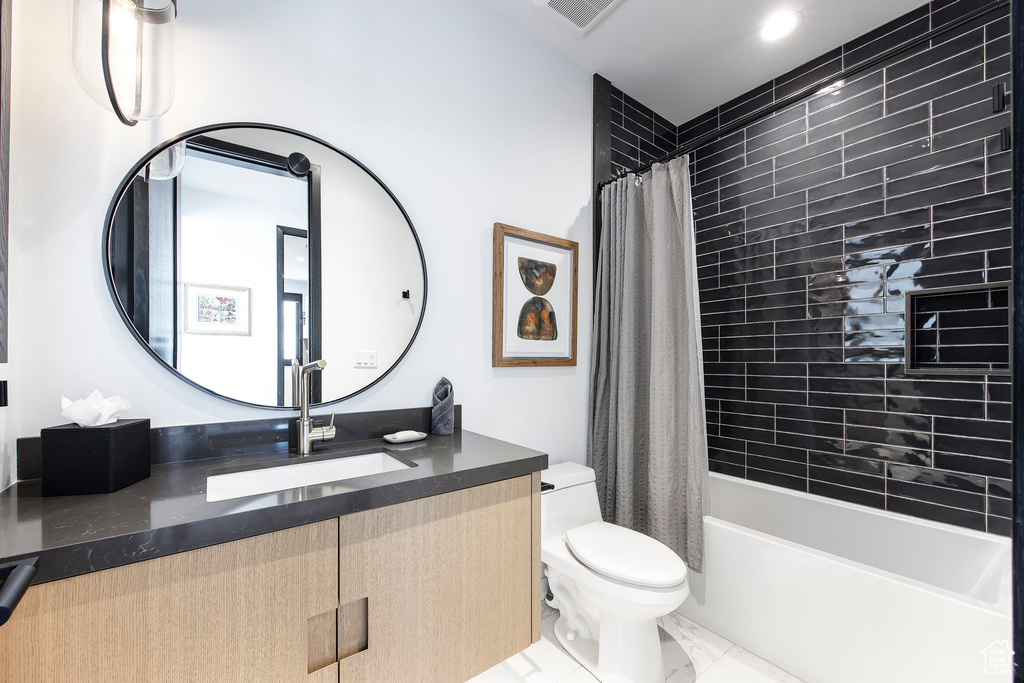 Full bath featuring toilet, vanity, shower / bath combo, and tile patterned flooring