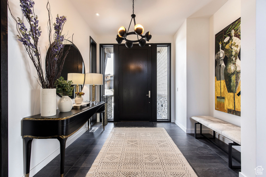 Entrance foyer with a chandelier, baseboards, and recessed lighting
