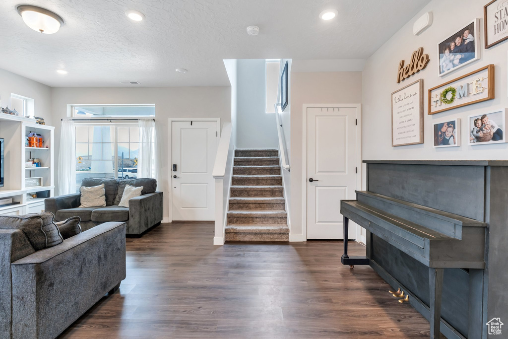 Living area featuring stairway, dark wood-style floors, recessed lighting, and baseboards
