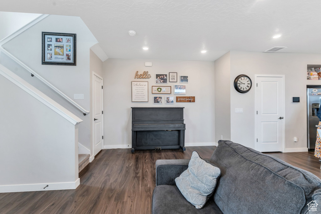 Living room featuring stairway, dark wood finished floors, recessed lighting, and baseboards