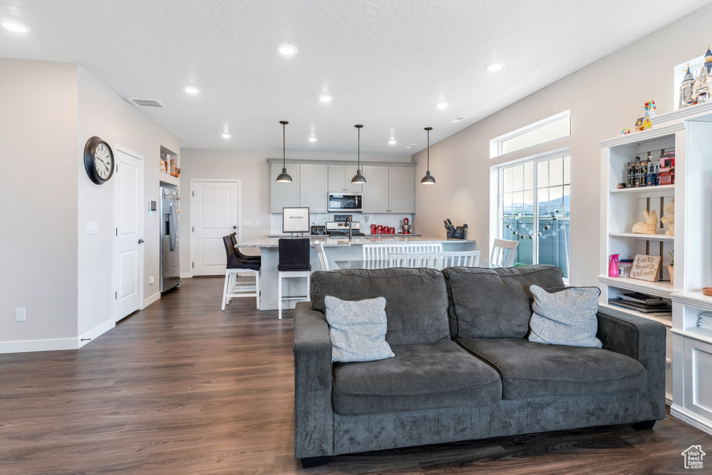 Living area featuring recessed lighting and dark wood-style floors