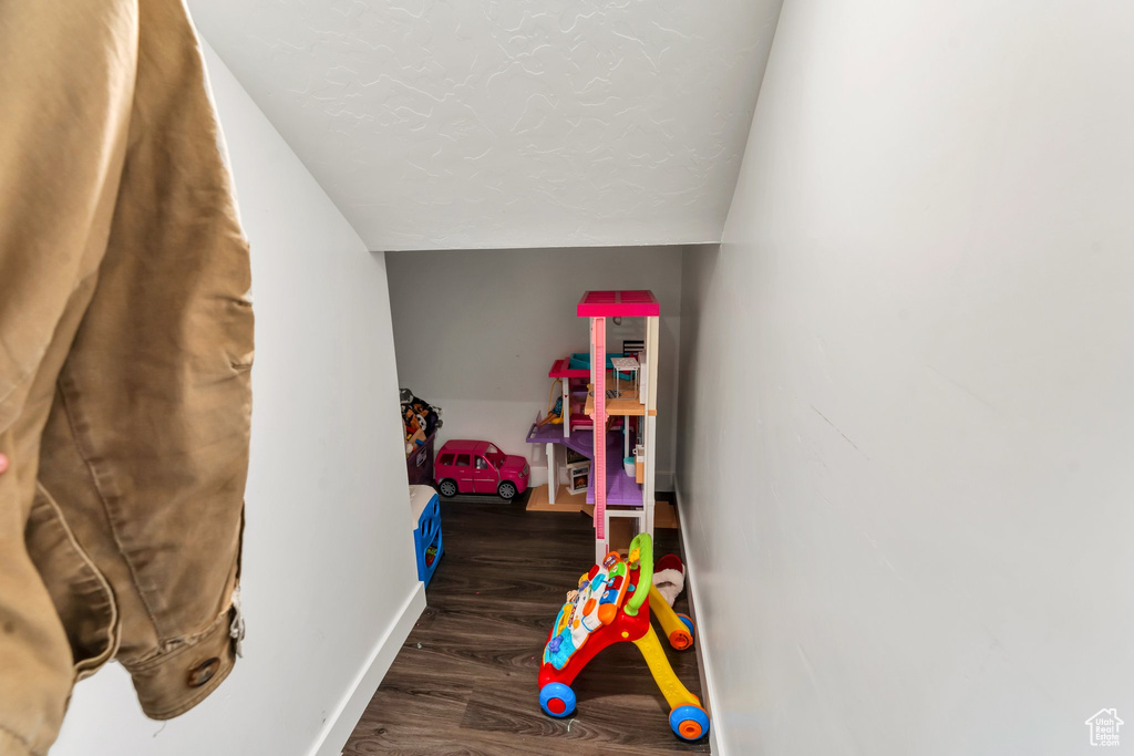 Game room with wood finished floors, baseboards, and lofted ceiling