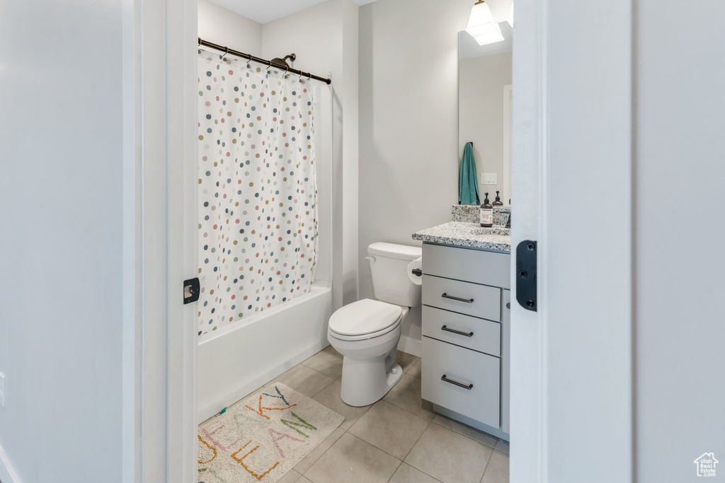 Full bathroom with tile patterned flooring, toilet, vanity, and shower / bathtub combination with curtain