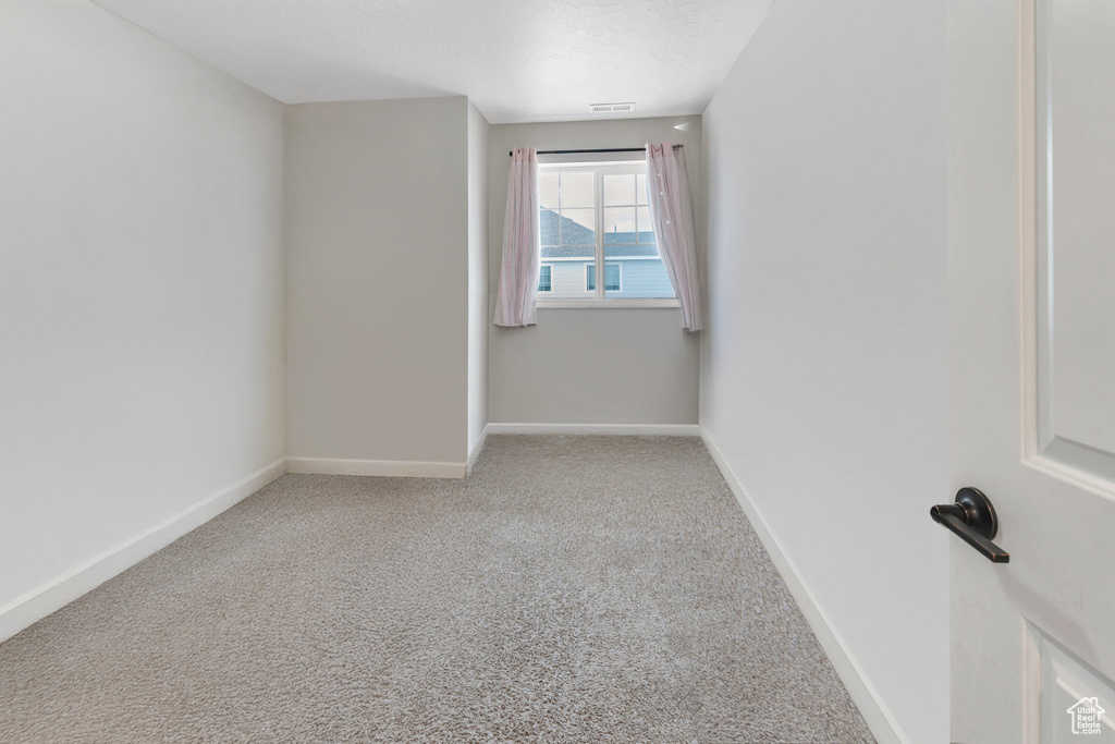 Carpeted empty room with baseboards