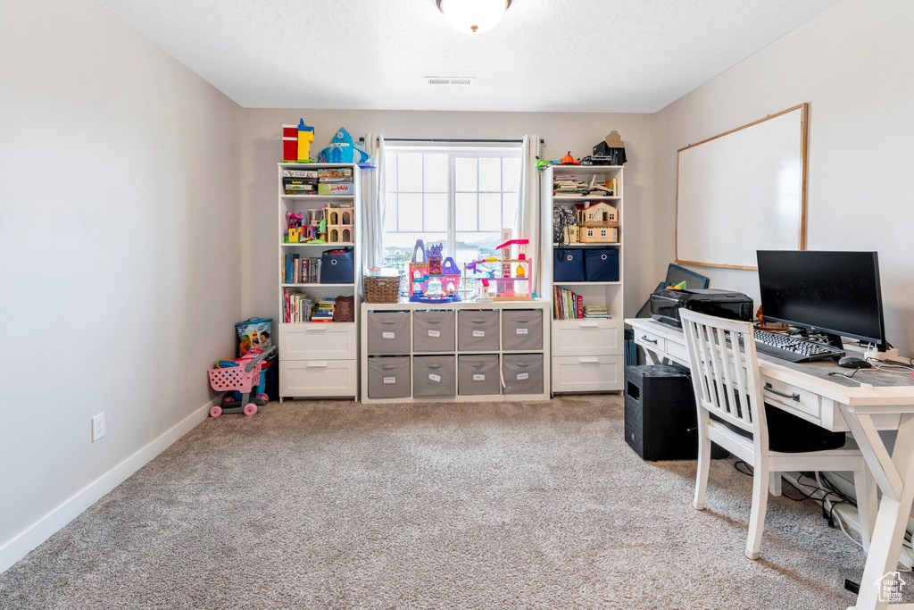 Home office featuring light carpet and baseboards