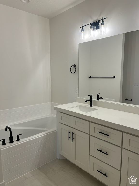 Bathroom with a bath, vanity, and tile patterned floors