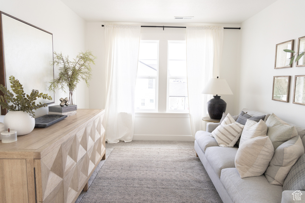 Living area featuring light carpet and baseboards
