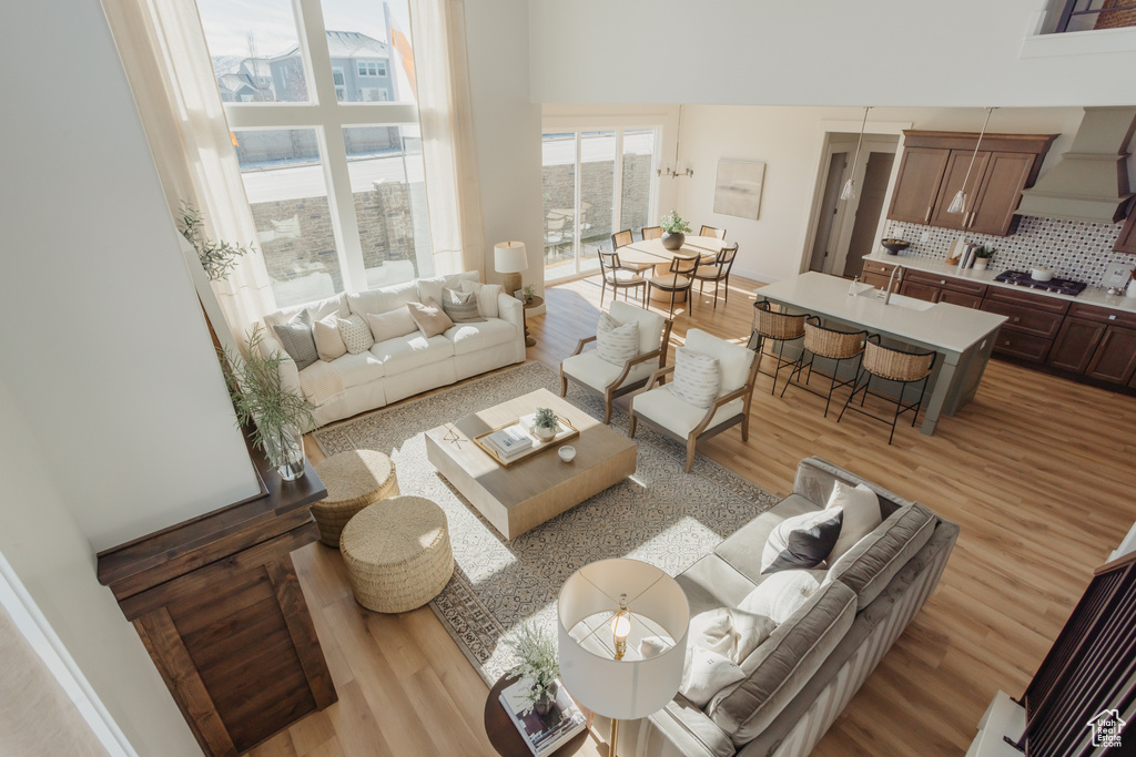Living room featuring a high ceiling and light wood-style flooring