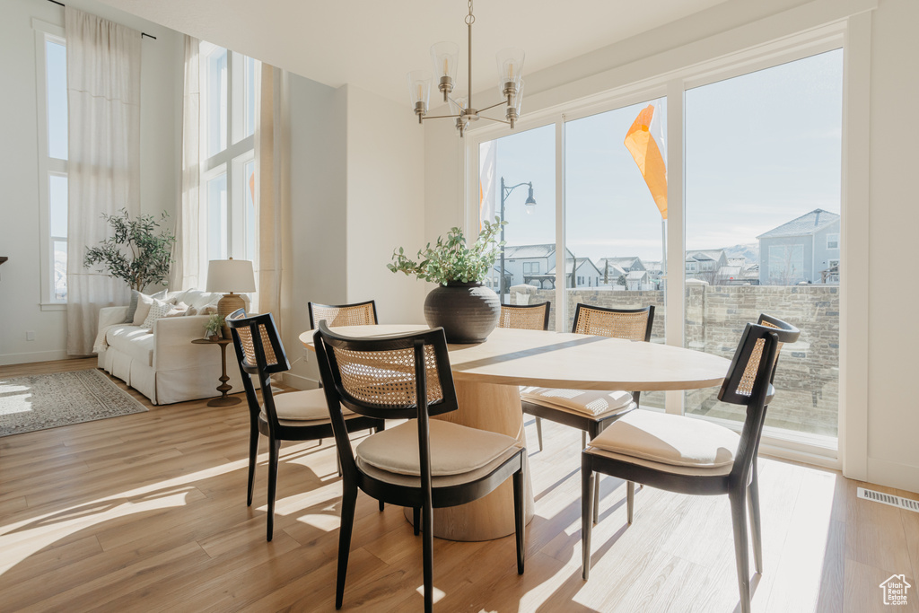 Dining area featuring plenty of natural light, a chandelier, and wood finished floors
