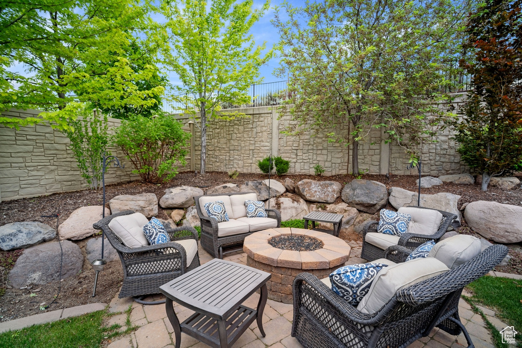 View of patio with a fenced backyard and an outdoor living space with a fire pit