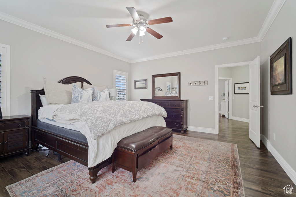 Bedroom featuring dark wood finished floors, crown molding, baseboards, and a ceiling fan