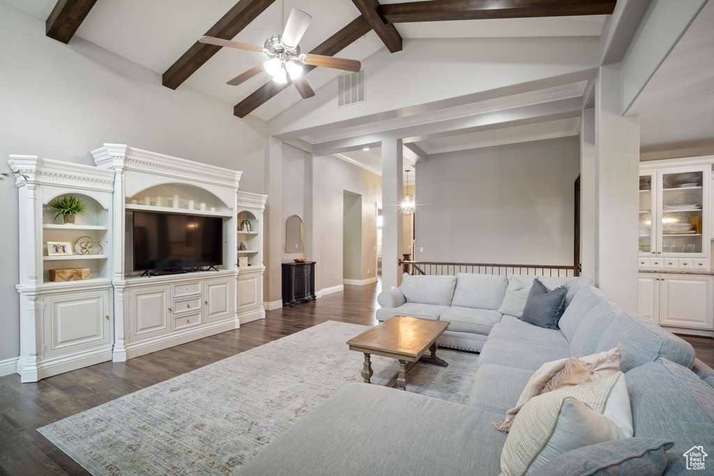 Living room featuring ceiling fan, beam ceiling, dark wood finished floors, baseboards, and high vaulted ceiling