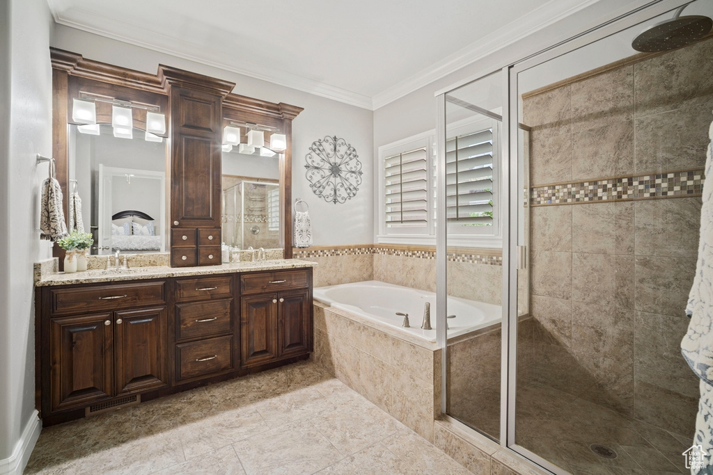 Full bath featuring a shower stall, a bath, double vanity, crown molding, and tile patterned floors