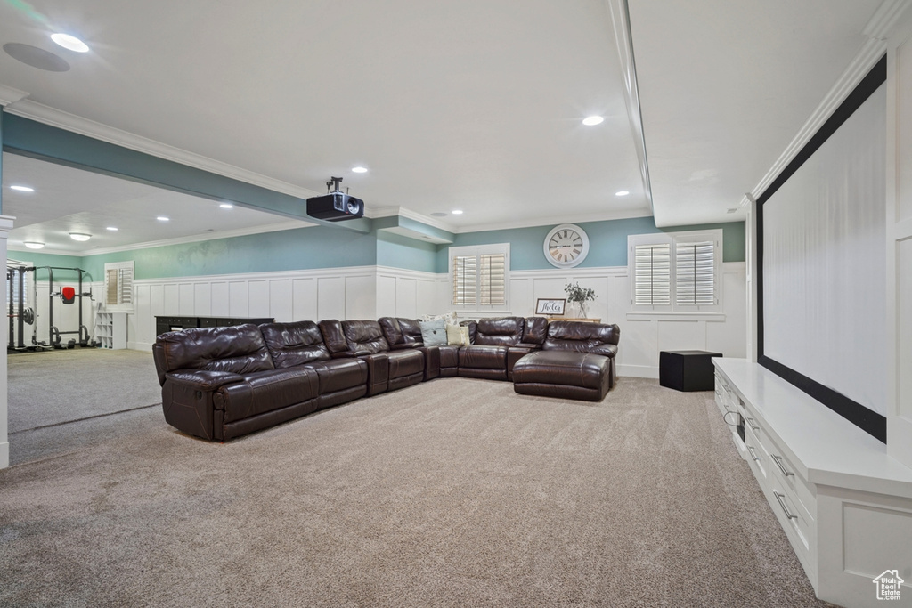 Carpeted cinema with ornamental molding, recessed lighting, wainscoting, and a decorative wall