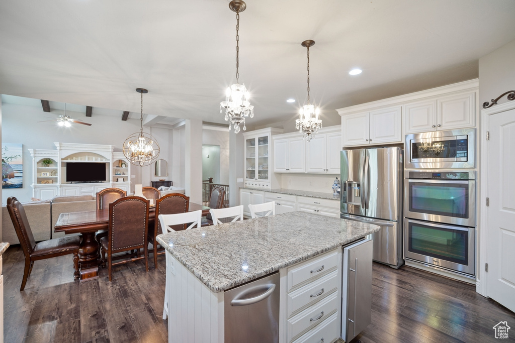 Kitchen featuring appliances with stainless steel finishes, a chandelier, a center island, dark wood finished floors, and recessed lighting