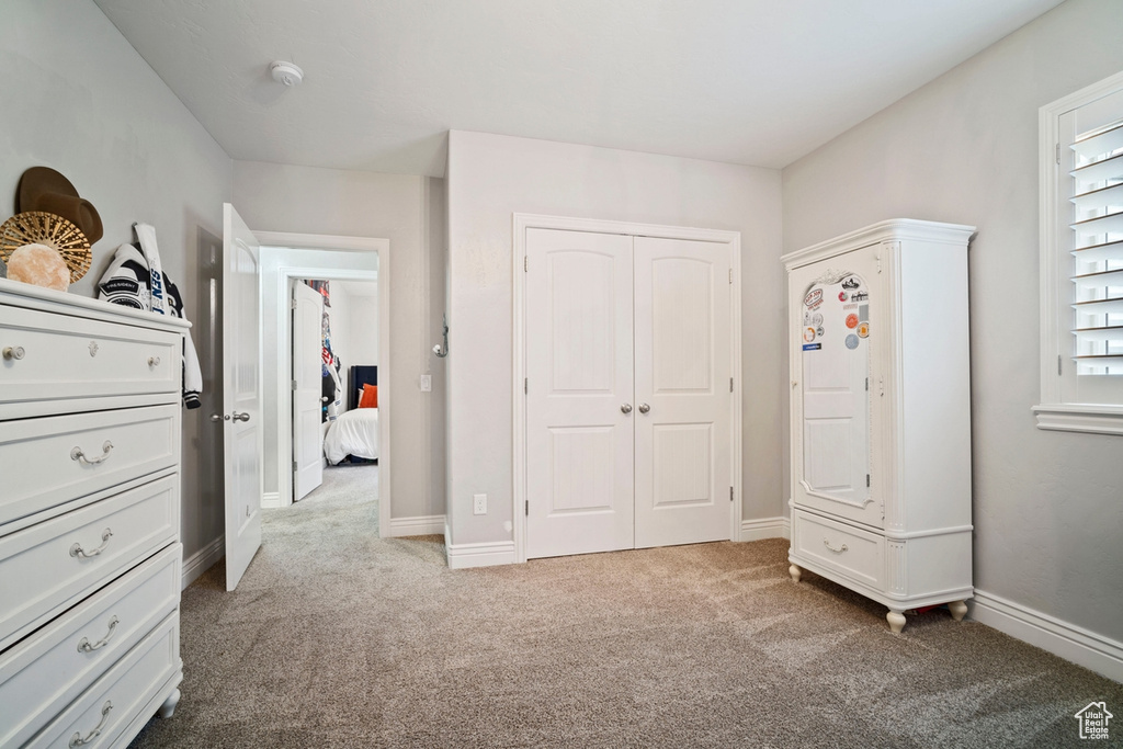 Carpeted bedroom with a closet and baseboards
