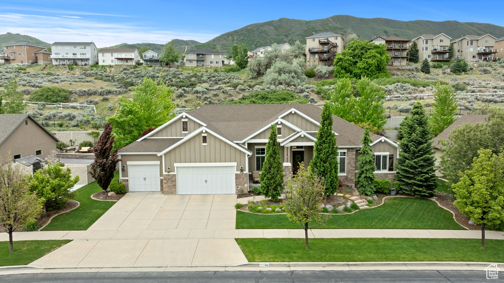 Craftsman-style home featuring board and batten siding, a mountain view, a residential view, and concrete driveway