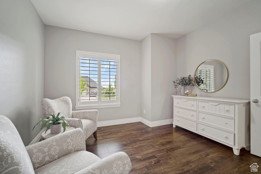 Living area with dark wood-style flooring and baseboards