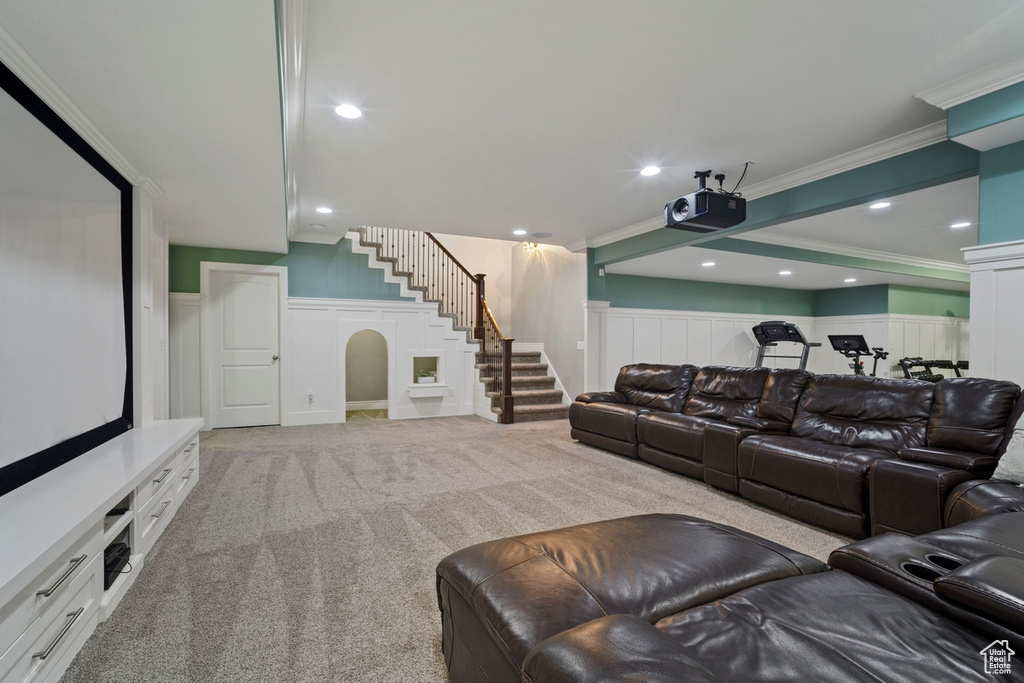 Home theater with a decorative wall, crown molding, wainscoting, light colored carpet, and recessed lighting