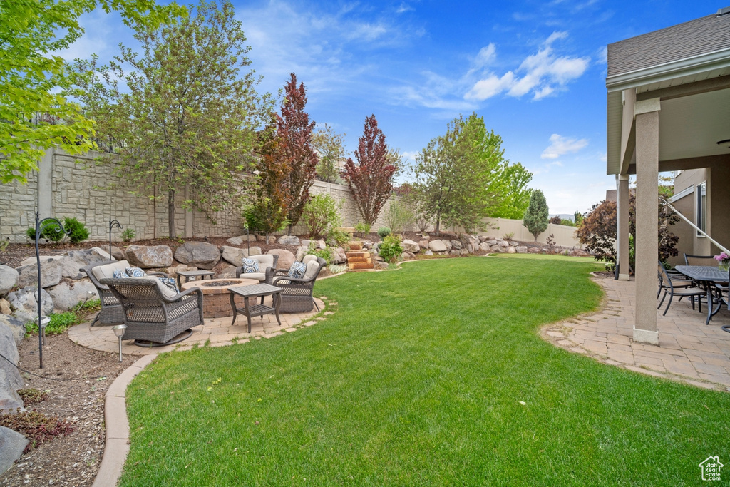 View of yard featuring an outdoor living space with a fire pit and a patio area