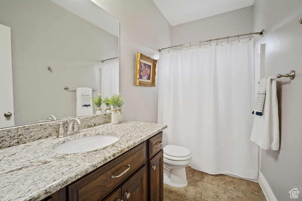 Full bathroom with toilet, vanity, and a shower with shower curtain