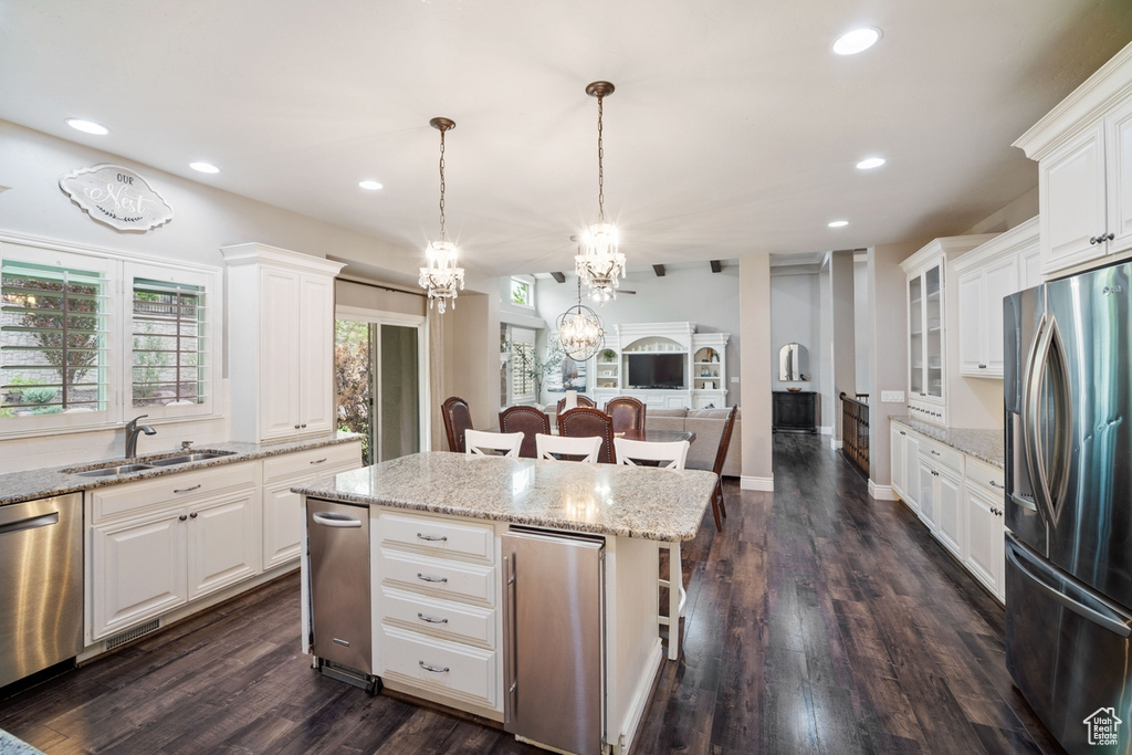 Kitchen with stainless steel appliances, a sink, a chandelier, recessed lighting, and a kitchen island
