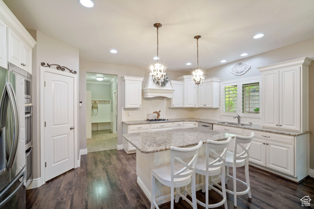 Kitchen featuring a sink, stainless steel appliances, white cabinetry, and recessed lighting