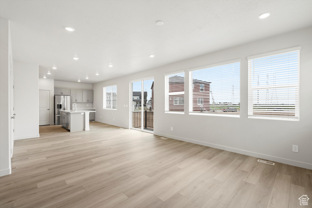 Unfurnished living room with light wood finished floors and recessed lighting