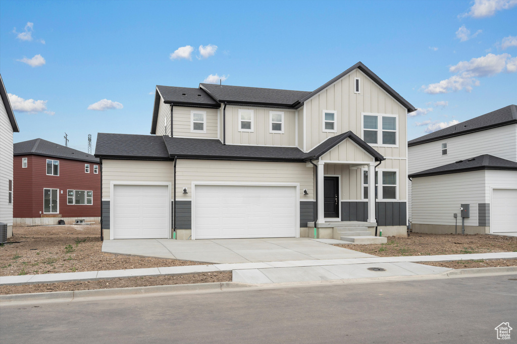 View of front of home featuring board and batten siding, a garage, and driveway