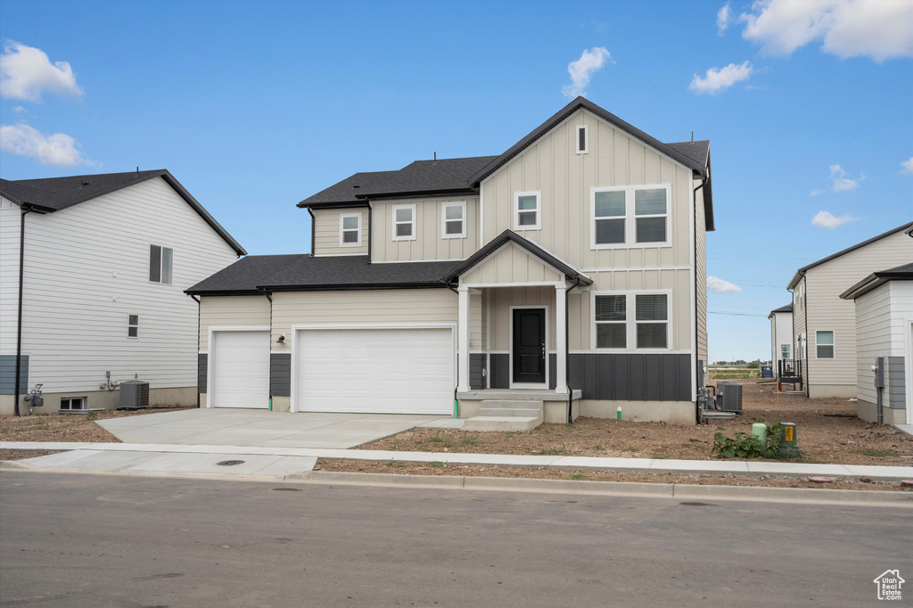 Modern farmhouse featuring board and batten siding, concrete driveway, and an attached garage
