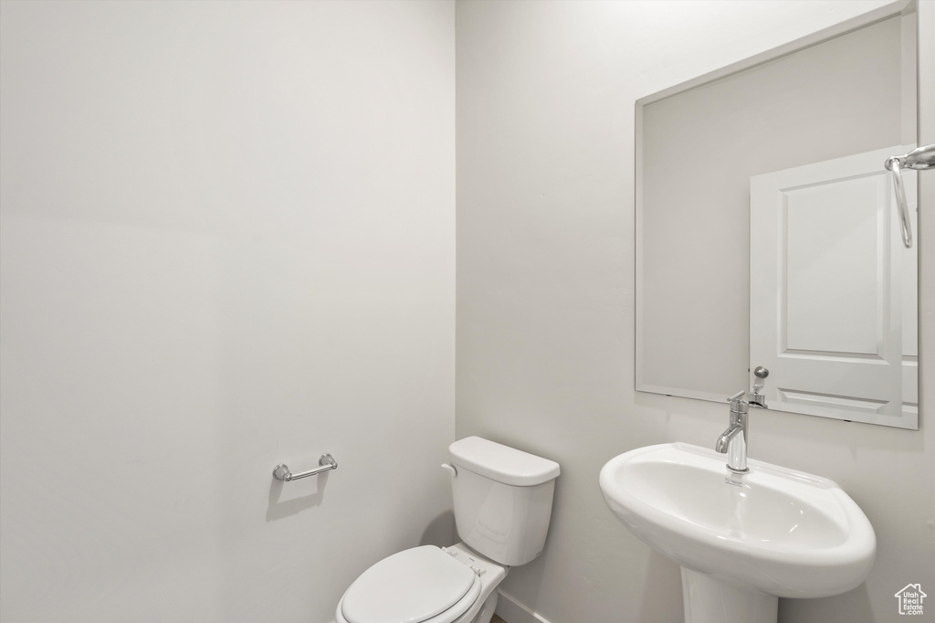 Half bath featuring toilet and a sink