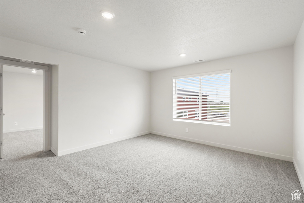 Unfurnished room featuring carpet, recessed lighting, and a smoke detector