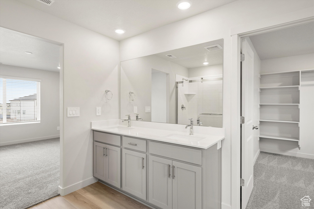 Full bath with a shower stall, double vanity, and recessed lighting