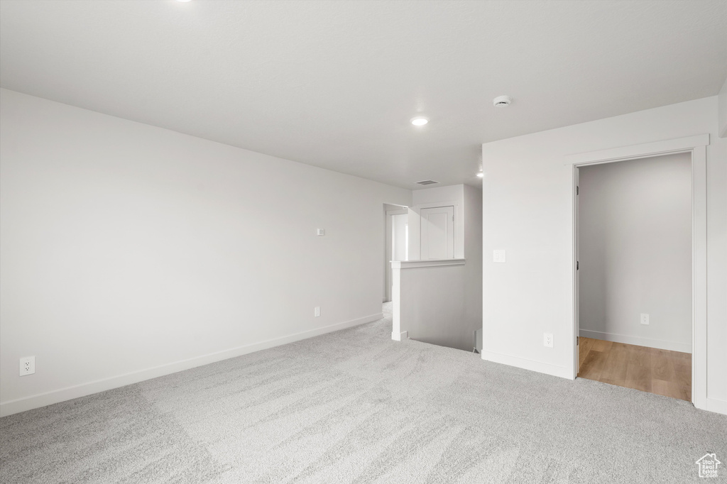 Unfurnished bedroom with light carpet and recessed lighting