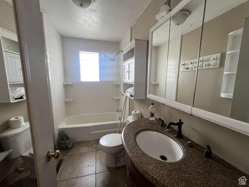 Bathroom featuring toilet,  shower combination, vanity, and tile patterned floors