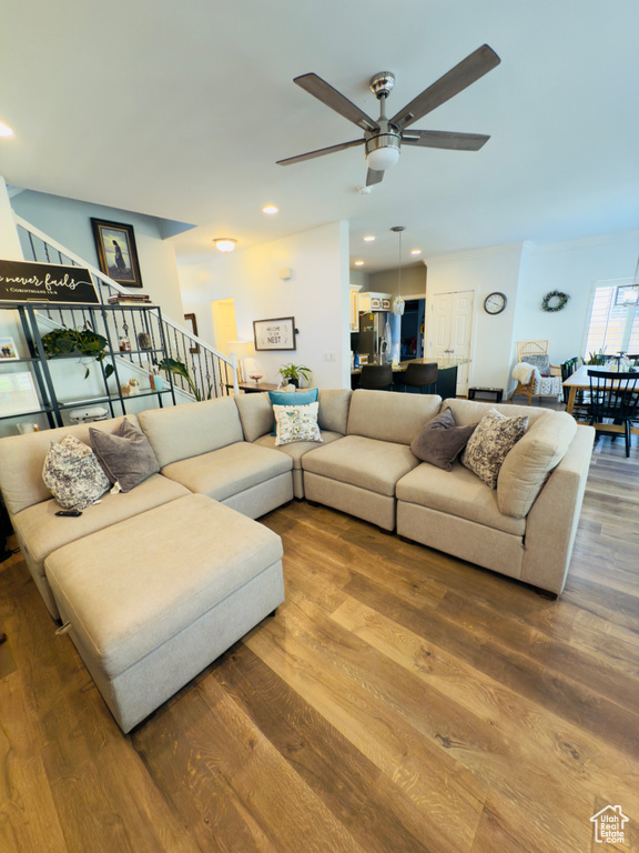 Living area with ceiling fan, wood finished floors, stairway, and recessed lighting