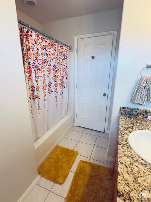 Bathroom featuring tile patterned flooring, baseboards, shower / tub combo with curtain, and vanity