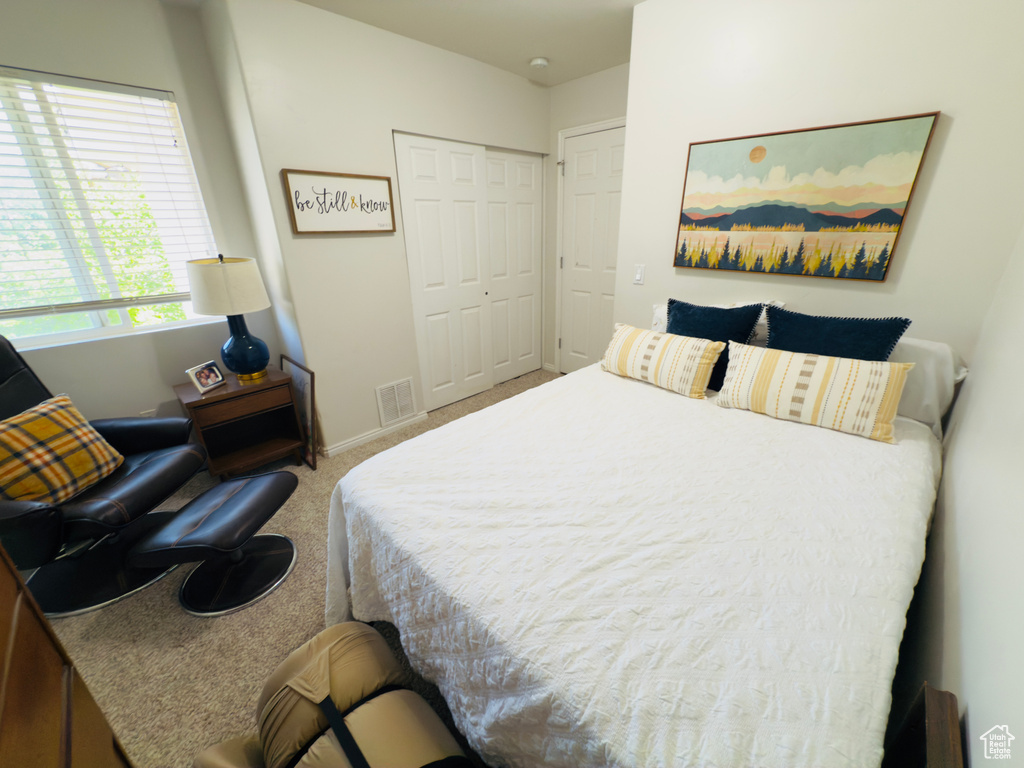 Carpeted bedroom featuring a closet and baseboards