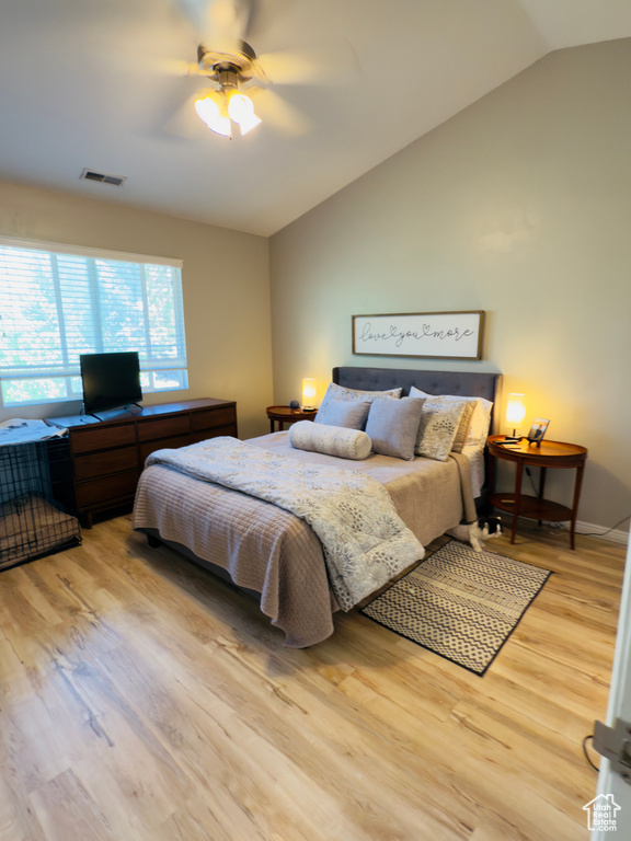 Bedroom with lofted ceiling, light wood-type flooring, a ceiling fan, and baseboards