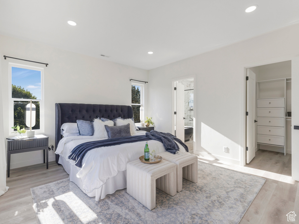 Bedroom with light wood-style flooring, recessed lighting, baseboards, and ensuite bathroom