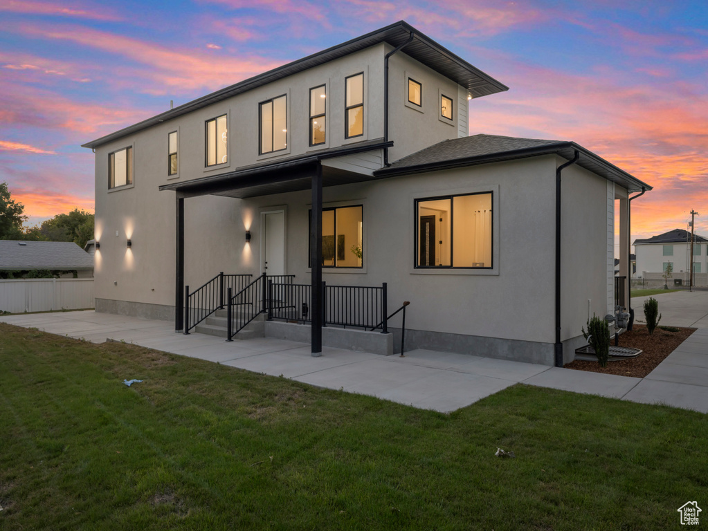 Back of house at dusk with a patio and stucco siding