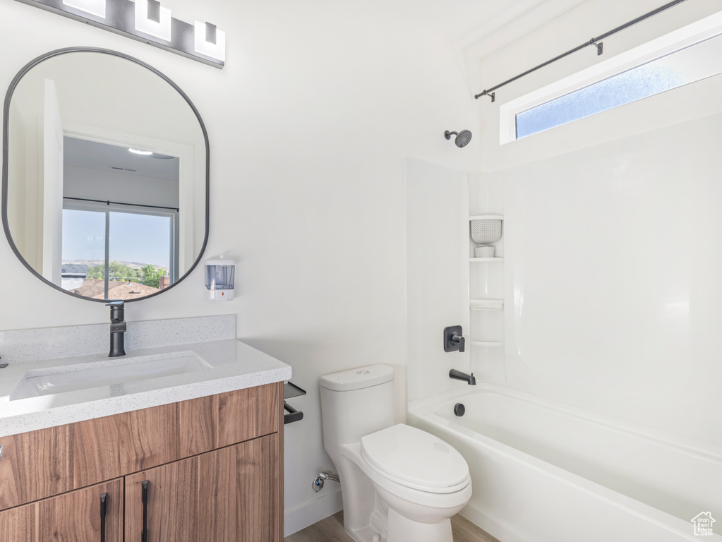 Full bathroom featuring toilet, shower / bath combination, vanity, and wood finished floors